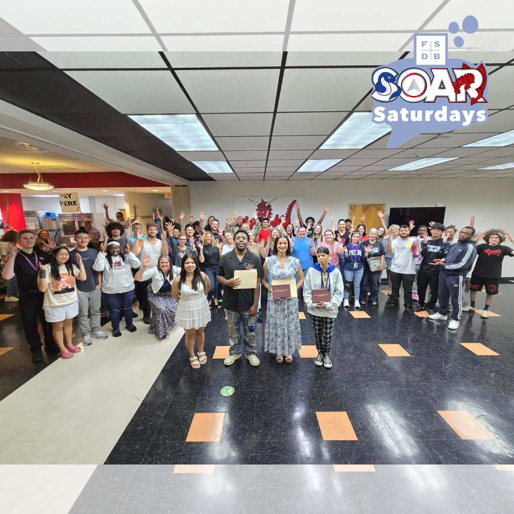 Wide shot of the three SOAR students with the SOAR group and staff member surrounding them inside the Dragon''s Lair.