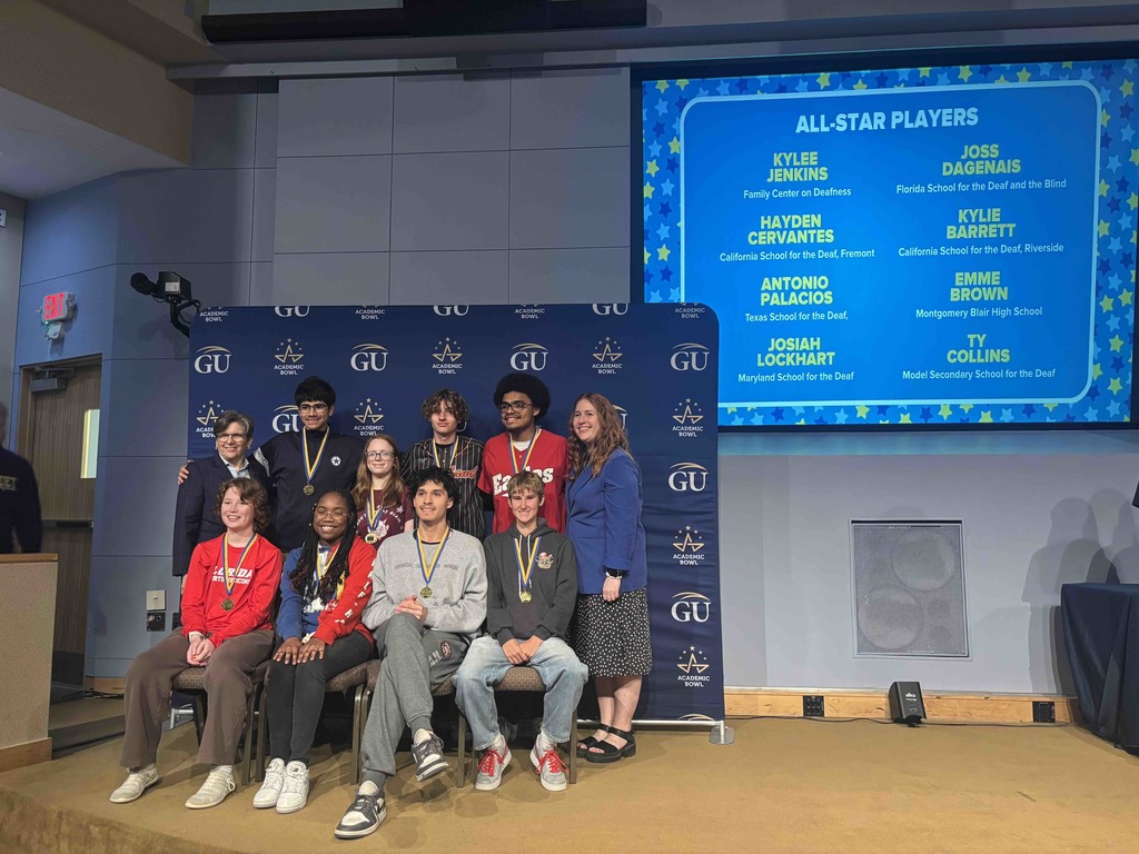 Wide shot photo of the All-Star Players from each school smile for a photo on stage. 