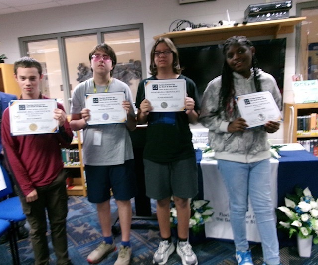 Students hold their certification smiles for a photo inside the library. 