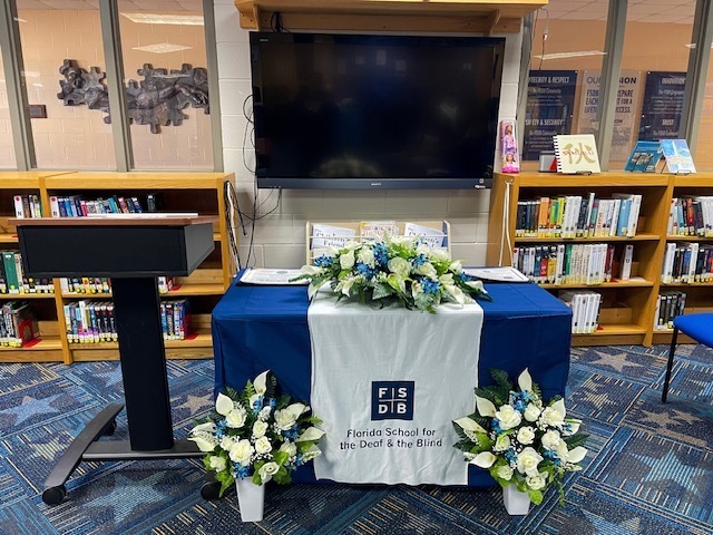 Photos of the Honor Roll set up with flowers inside the library. 