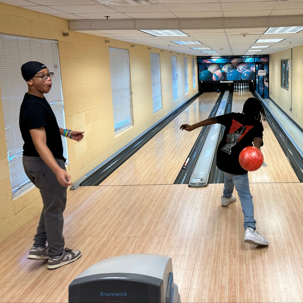 Two students are bowling inside Cobras Corner.