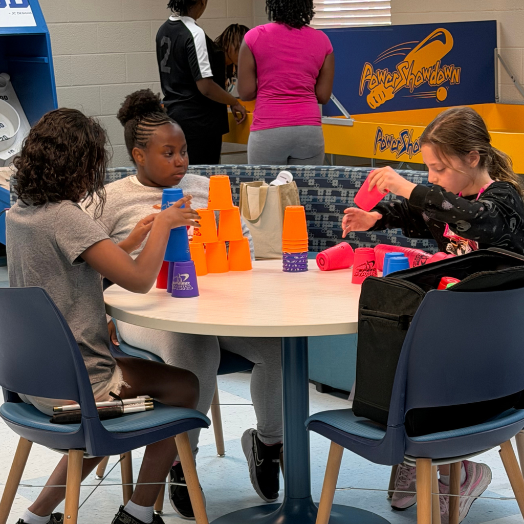 Group of students playing stacking with cups games inside Cobras Corner. 