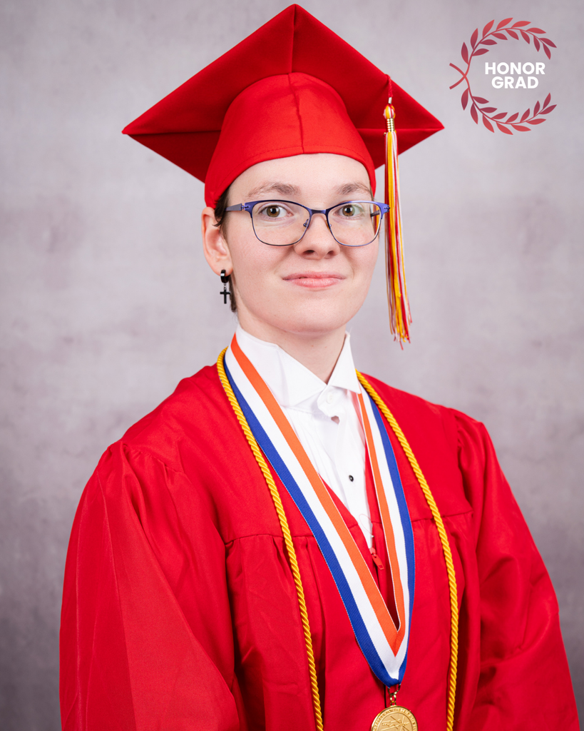 Nikki is smiling for her photo wearing her red cap and gown. 