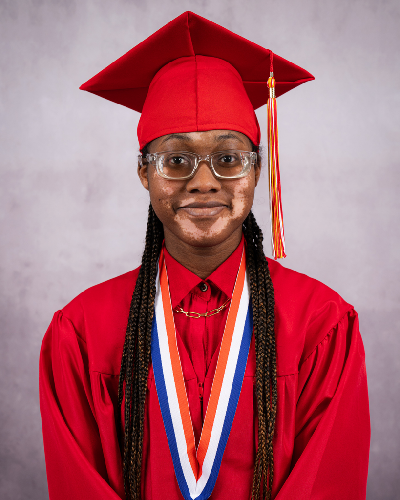 Nebreya is smiling for her photo wearing her red cap and gown.