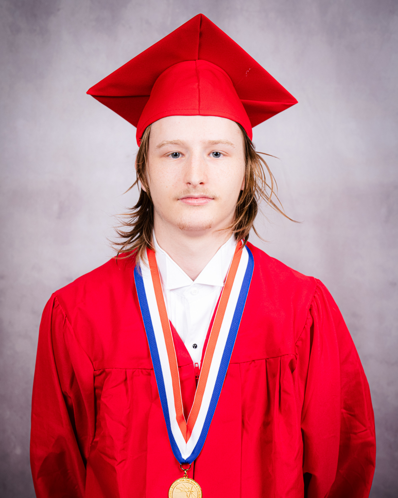 Lucius smiles for his photo wearing his red cap and gown. 