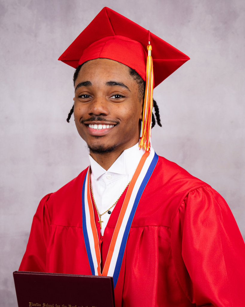 Xavier smiles for his photo wearing his red cap and gown. 