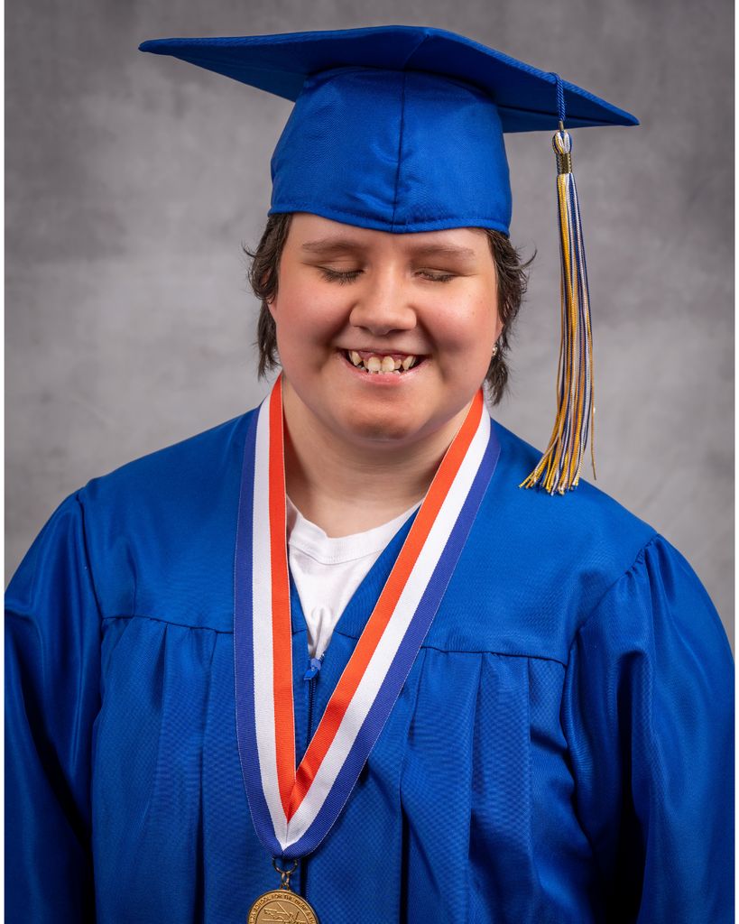 Janna is smiling for her photo wearing a blue cap and gown. 