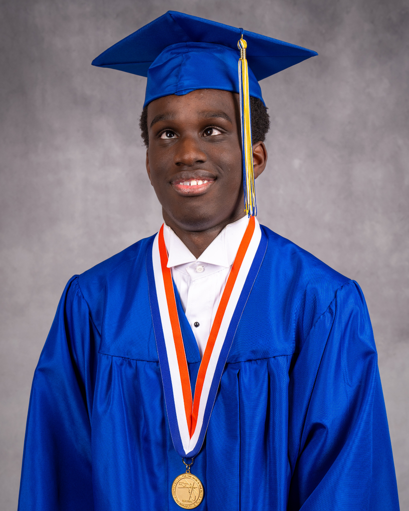 Jayden smiles for a photo in his blue cap and gown. 