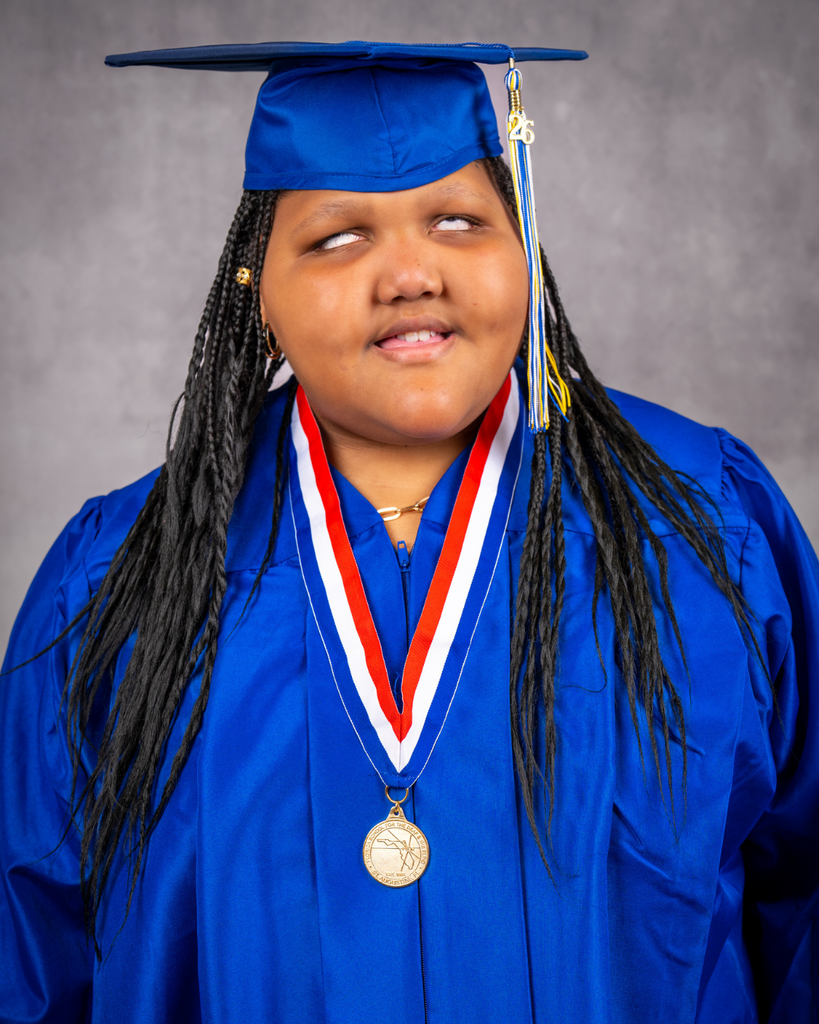 Isabelle smiles for her photo in her blue cap and gown.