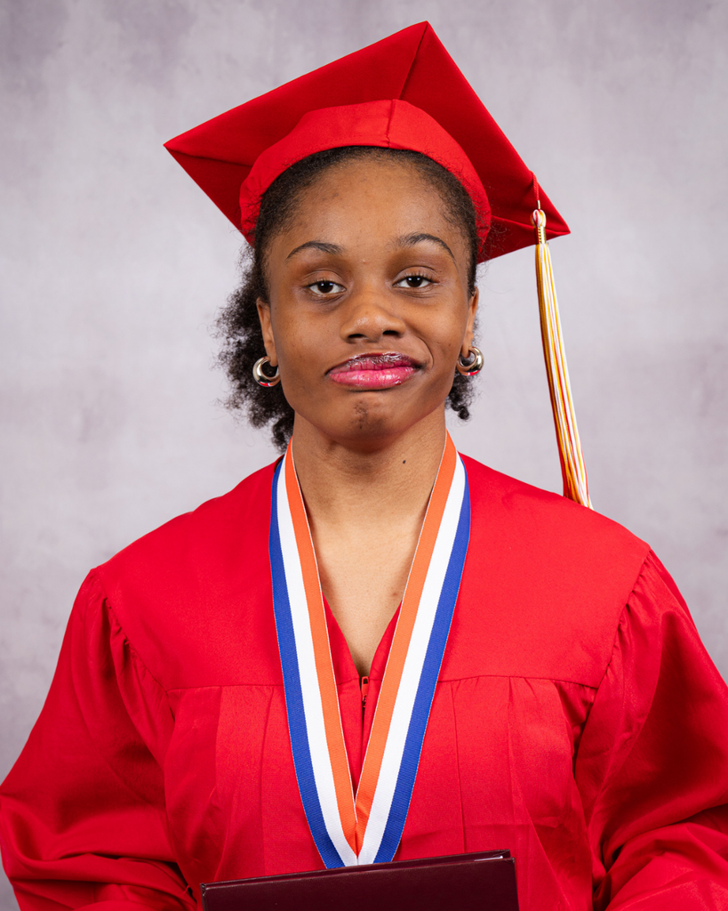 Chelcie smiles for her photo in her red cap and gown.