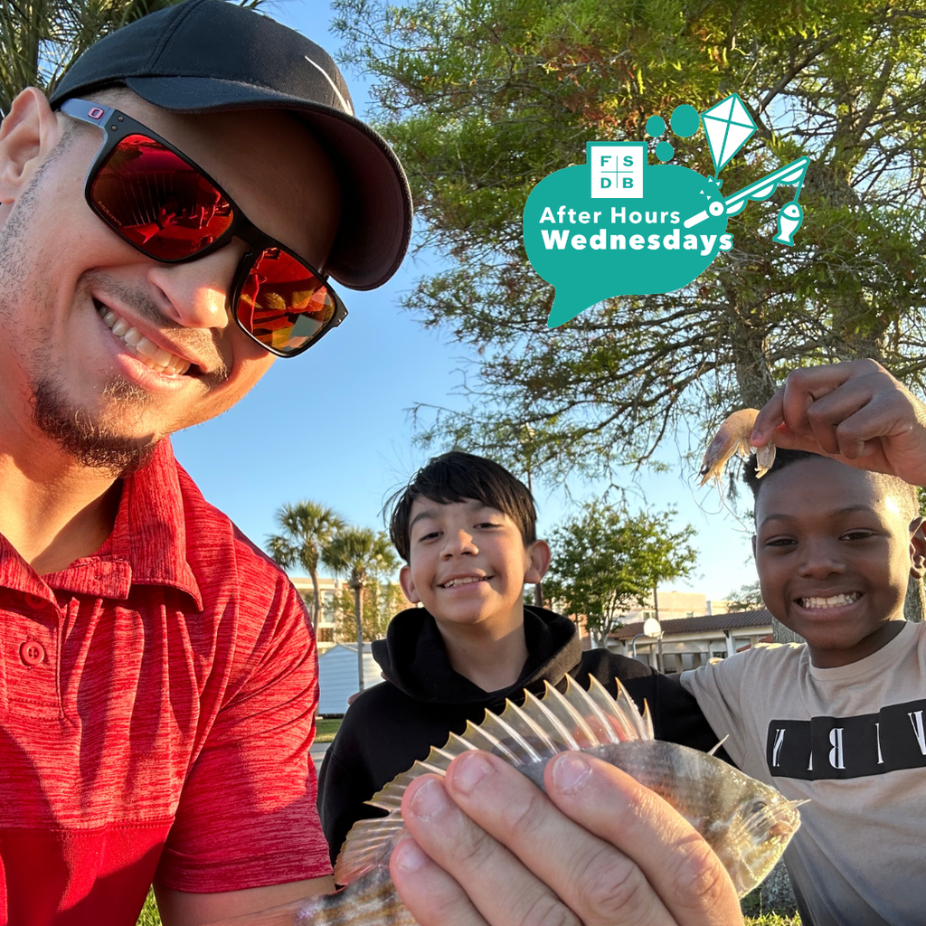 Selfie of staff member with students holding their fish and shrimp they caught outside by the water at FSDB.