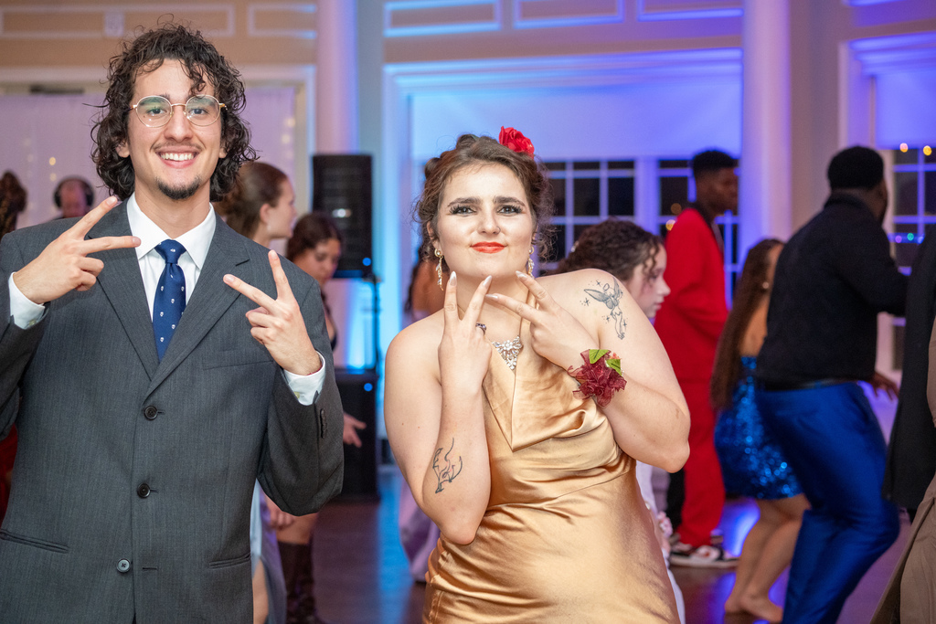 Two students pose with peace signs inside River House dance floor. 