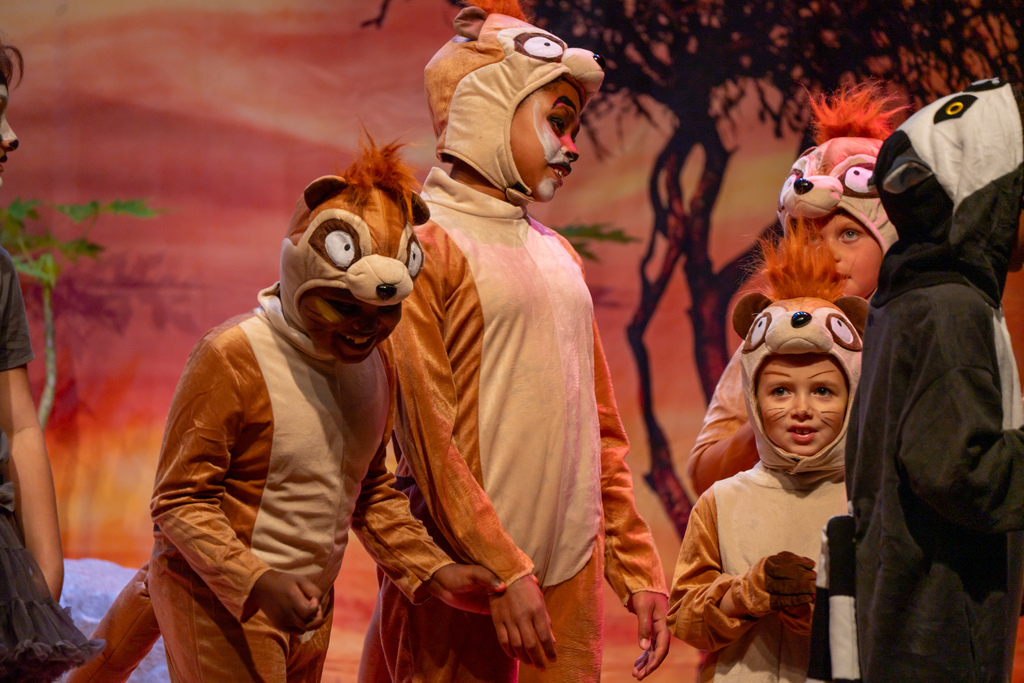 A group of students dressed like chipmunks on stage in the music building. 