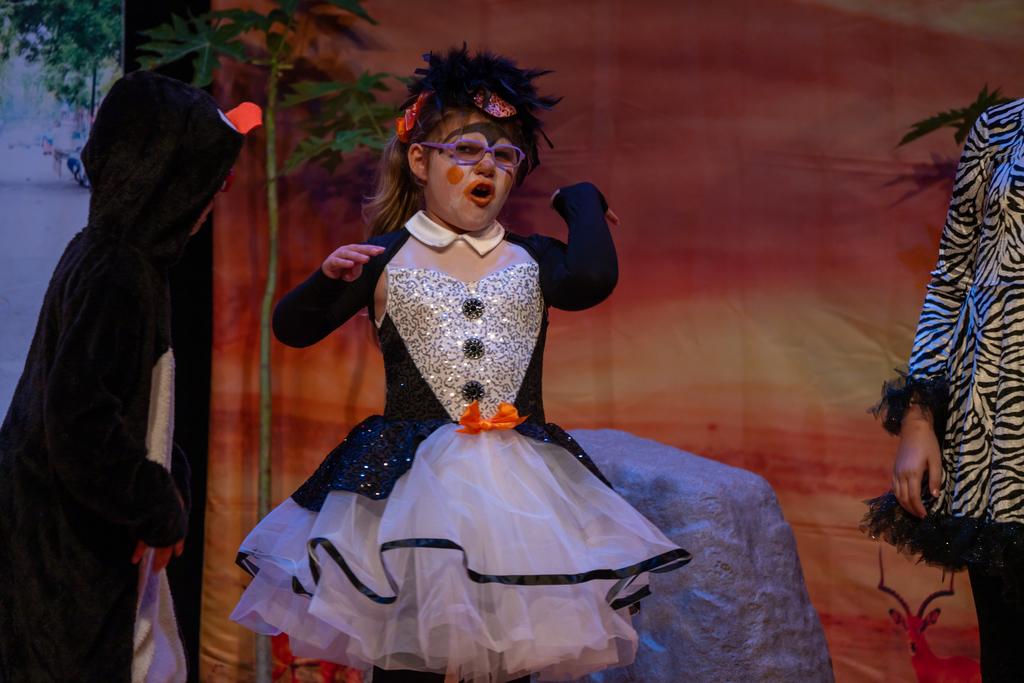 A student dressed like a penguin on stage in the Music Building. 