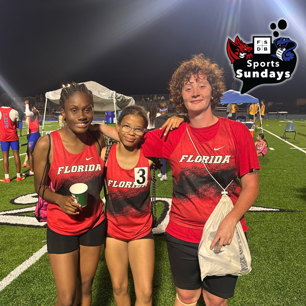 Three track and field wearing FSDB track and field uniforms smile for a photo. 