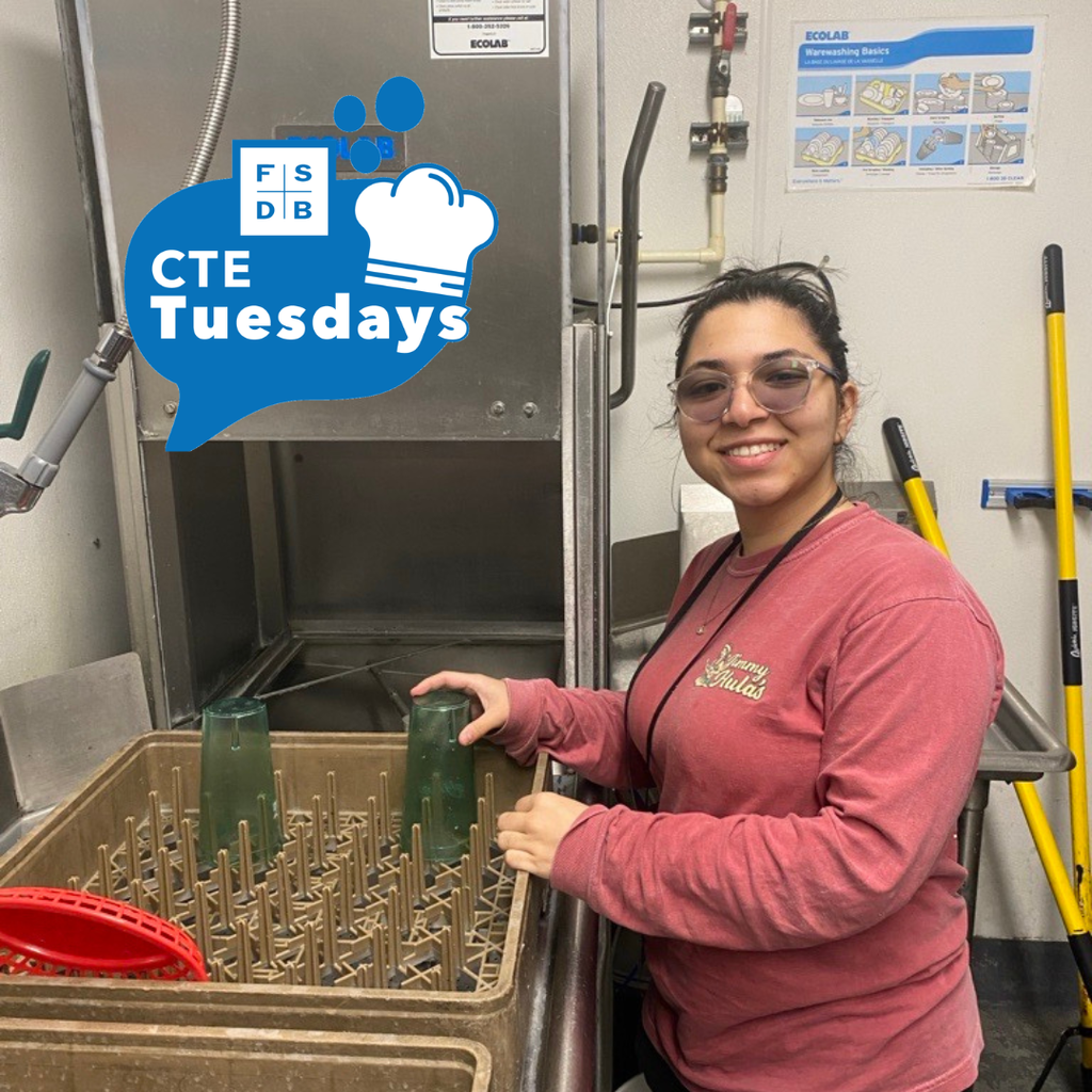 Andera smiles for her photo while cleaning dishes.