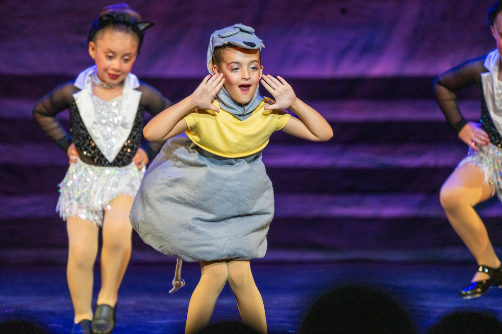 A student dressed like a mouse dance on stage in Kirk.