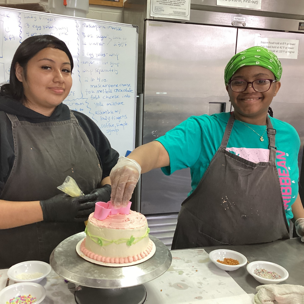Two students work together on a Mothers Day cake. 