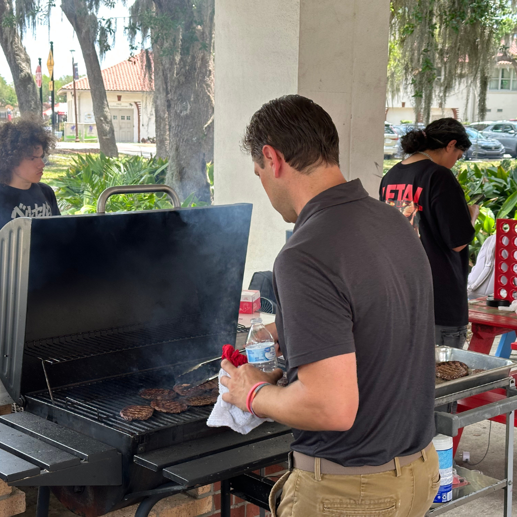 Ryan, Deaf Principal, grills burgers outside the Pavilion.