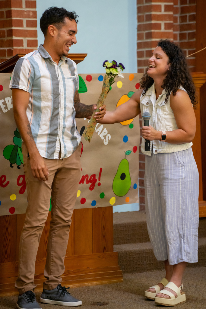 ELC Director hands flowers to an FSDB staff inside the Chapel. 