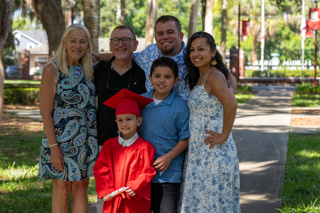 A family smiles with their ELC Deaf Graduate at Palm Row. 