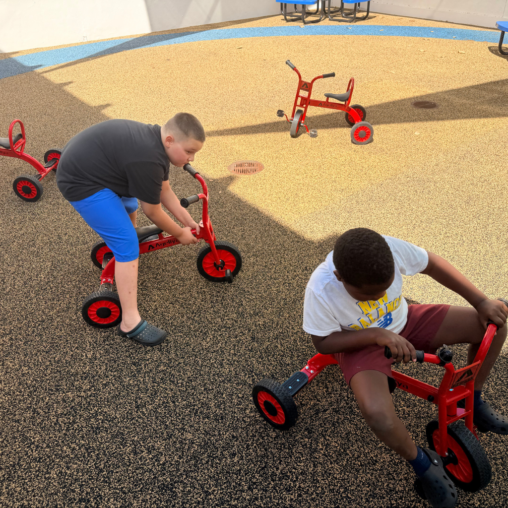 Two students riding bikes enjoying the new outdoor space.