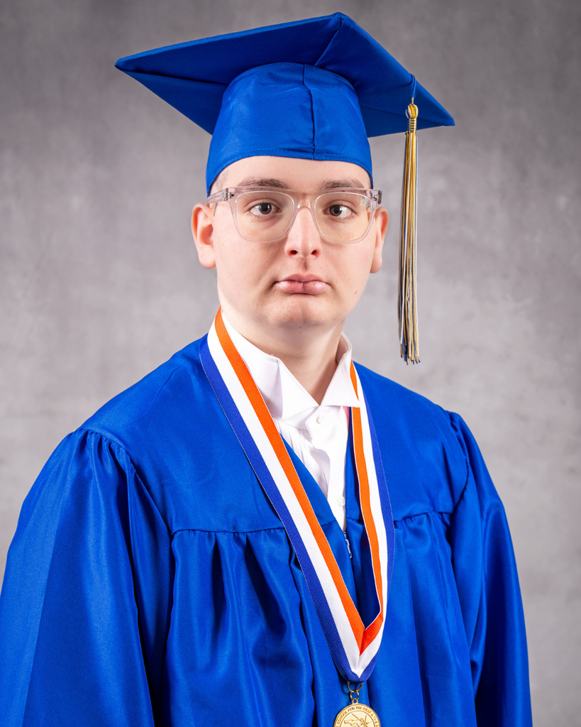 Eligio is wearing a blue cap and gown smiling for his photo.