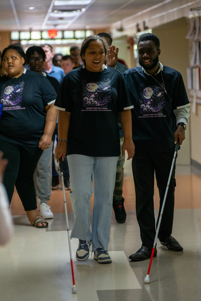 A few seniors smiling as they walk down the hallway during Cobra Walk.