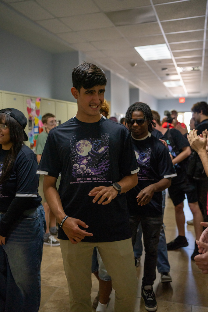 A senior smiles as he walks down the hallway during Cobra Walk.