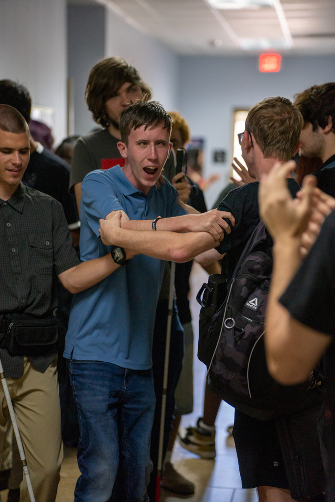 A senior getting cheered on as he walks down the hallway during Cobra Walk.