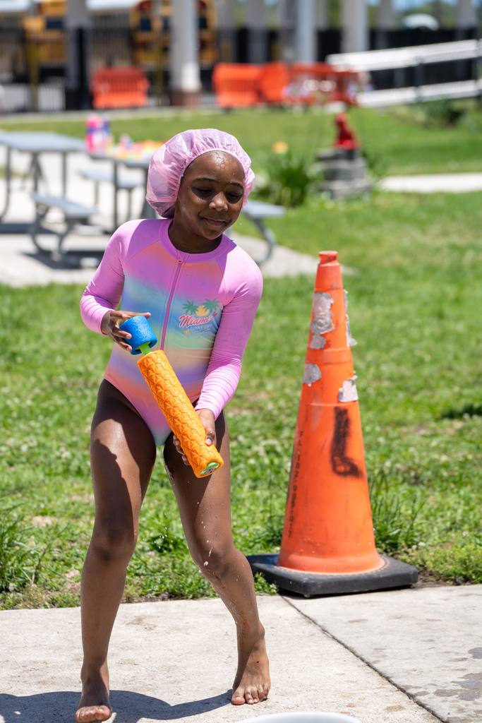A student is holding a squirt gun getting ready to spray someone with water.