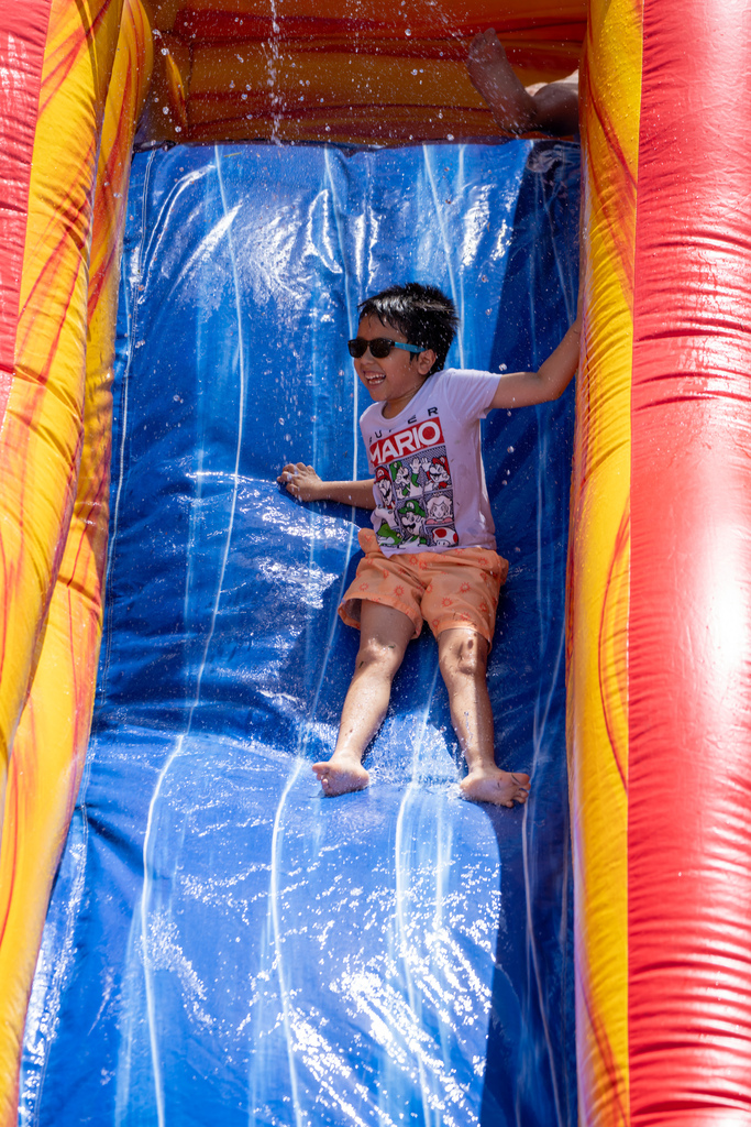 A student smiles as he goes down the water slide.