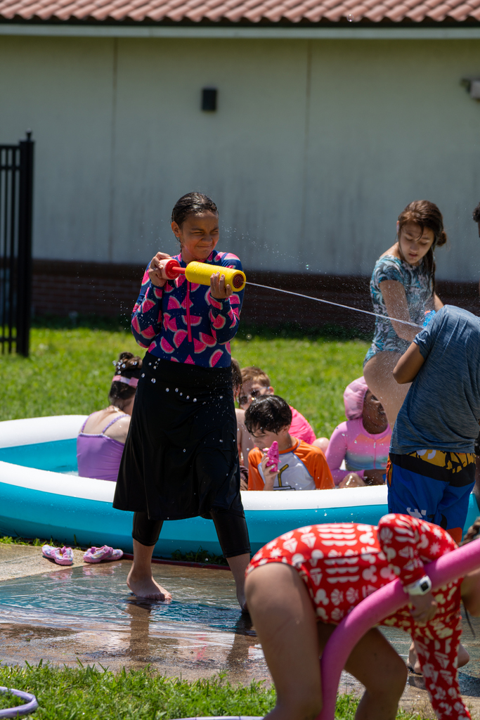 A student uses the squirt gun to spray someone with water.