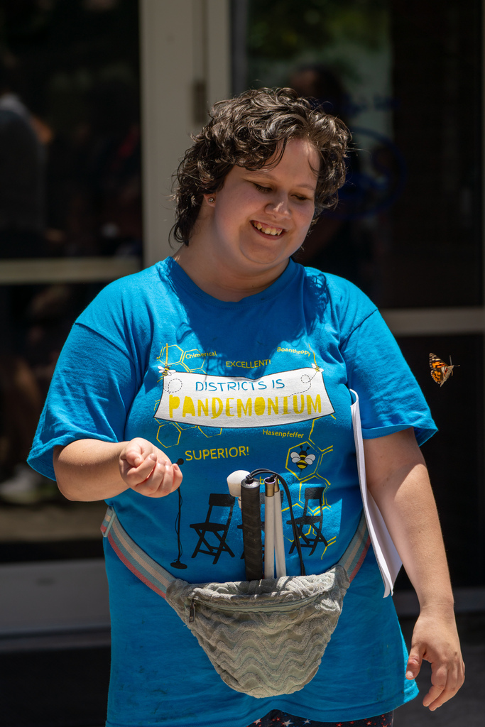 A student holding her hand out for the butterfly.