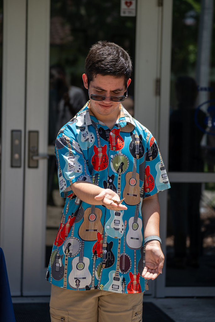A student holding his hand out for the butterfly.