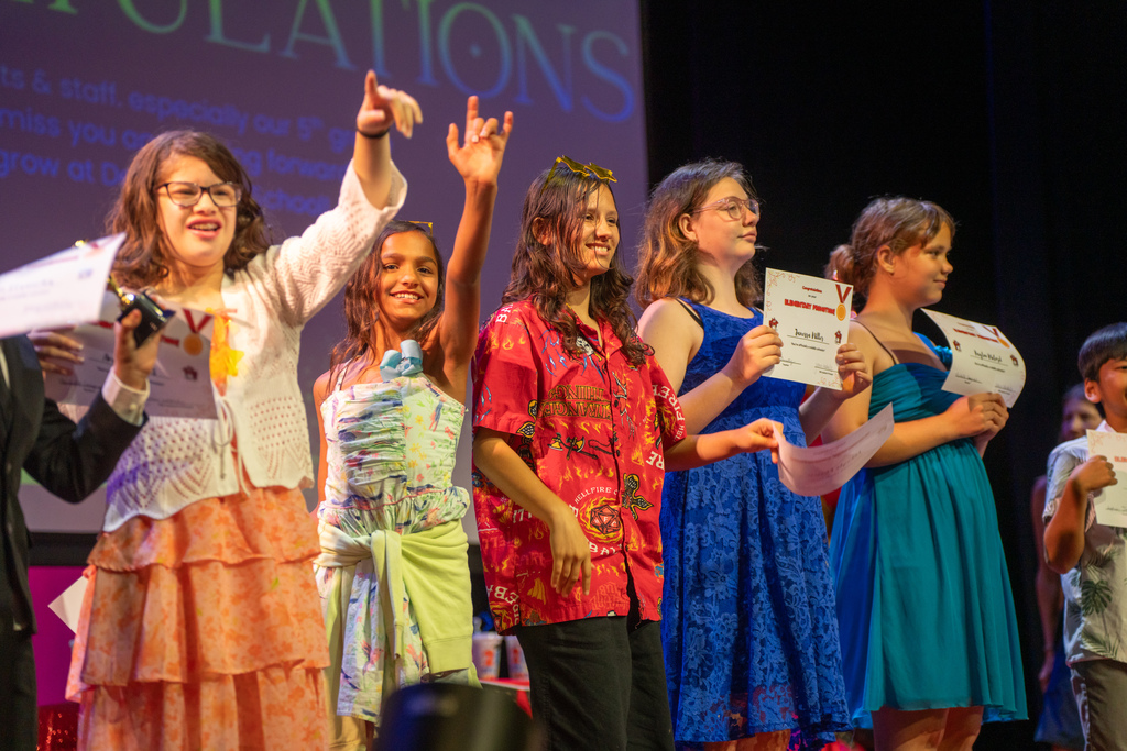 A group of students look to the crowd on stage in Kirk. 