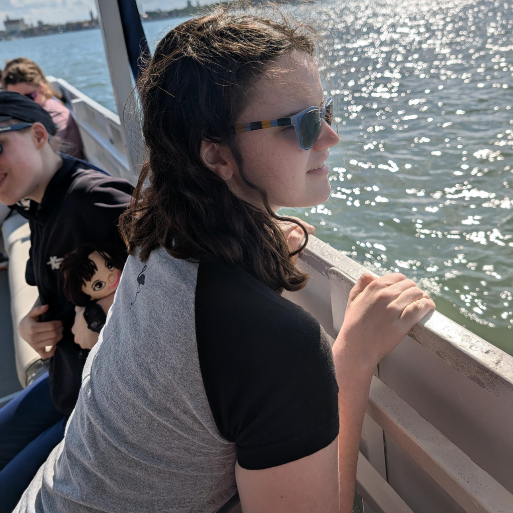 A student looks out on the water from the boat.