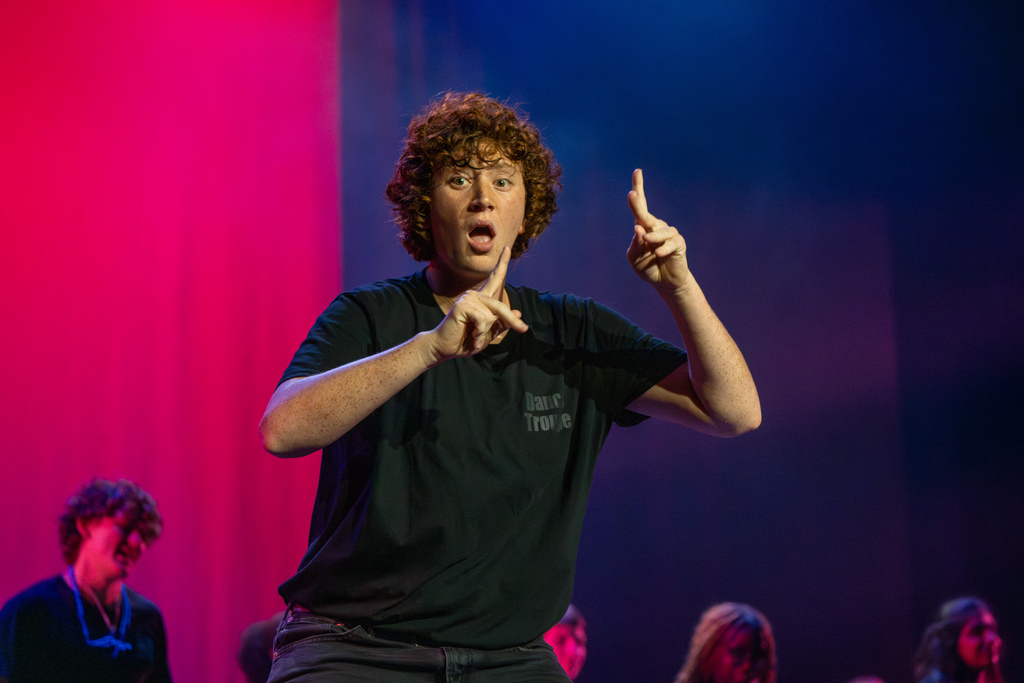 A student is signing on stage in Kirk. 