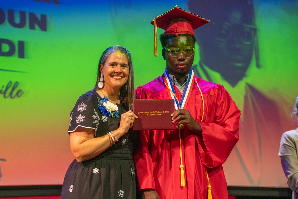 Tracie Snow smiles with a deaf senior on stage in Kirk. 