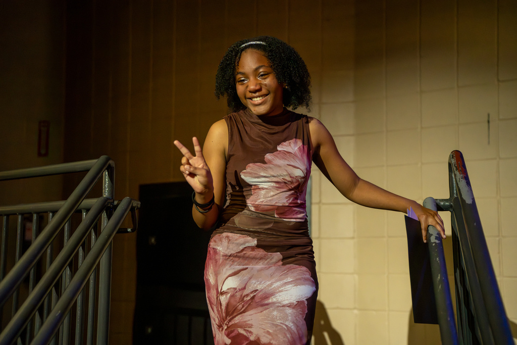 A student pose a peace sign on stage in Kirk. 