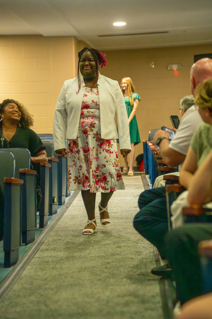 A 8th grade student walks down the aisle in Kirk. 