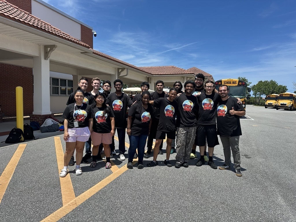 SOAR students smiling for a photo by the buses before they head off home for the summer.