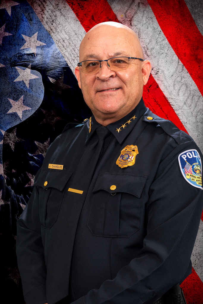 Jerry smiling in his uniform with an American flag in the background. 