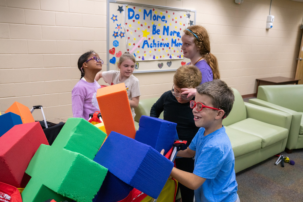 Students play together with foam blocks inside Cary White.