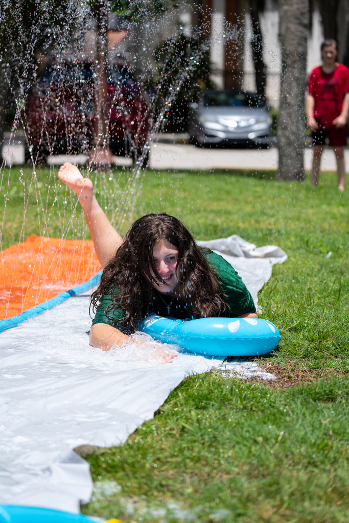 Student on slip and slide outside Palm Row.