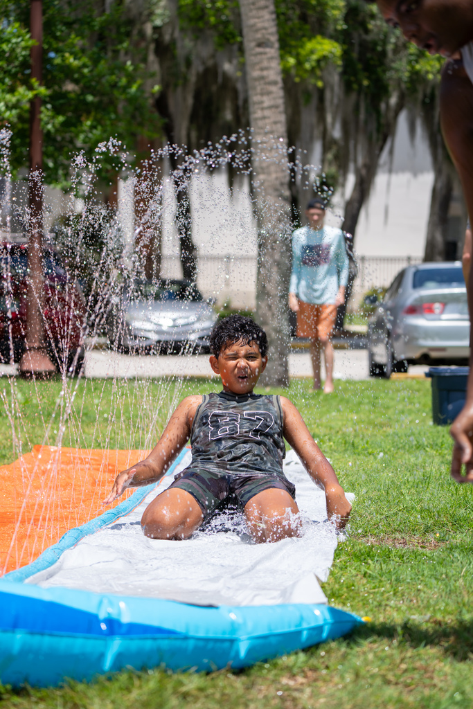 Student on slip and slide outside Palm Row.