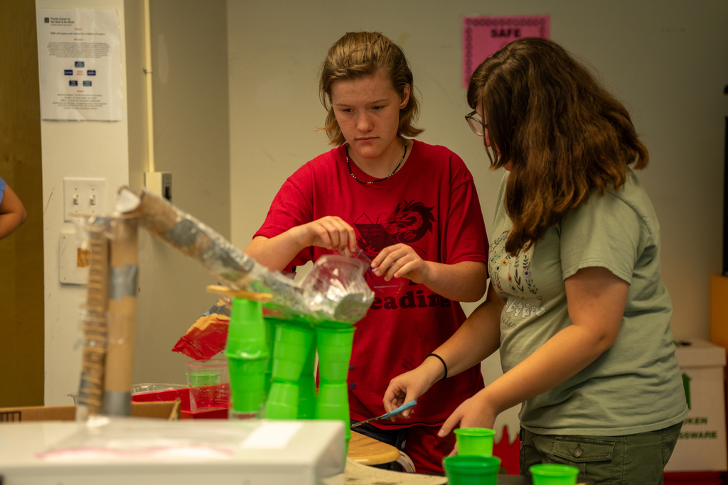 Students work on their egg drop creation inside the classroom.
