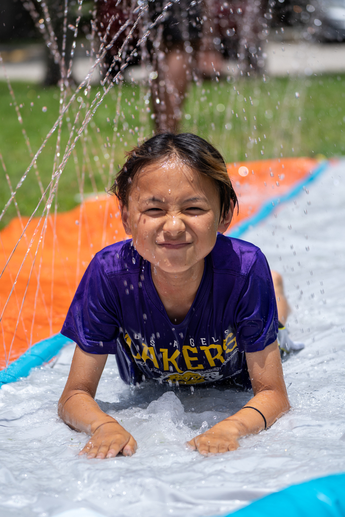 Student on slip and slide outside Palm Row.