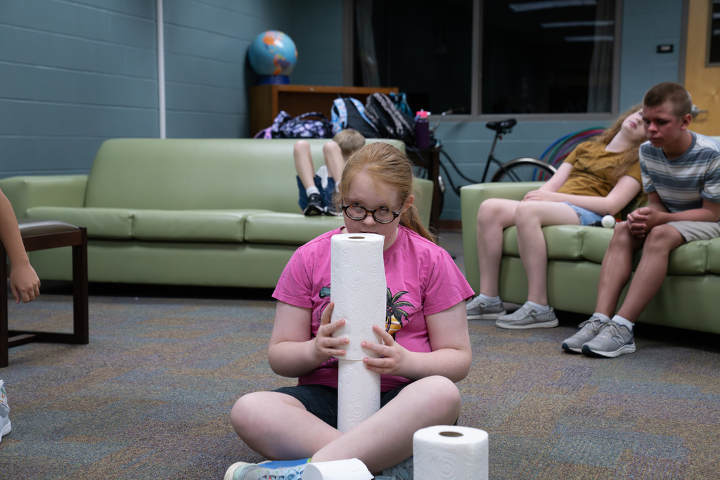 A student is building a tower with paper towels.