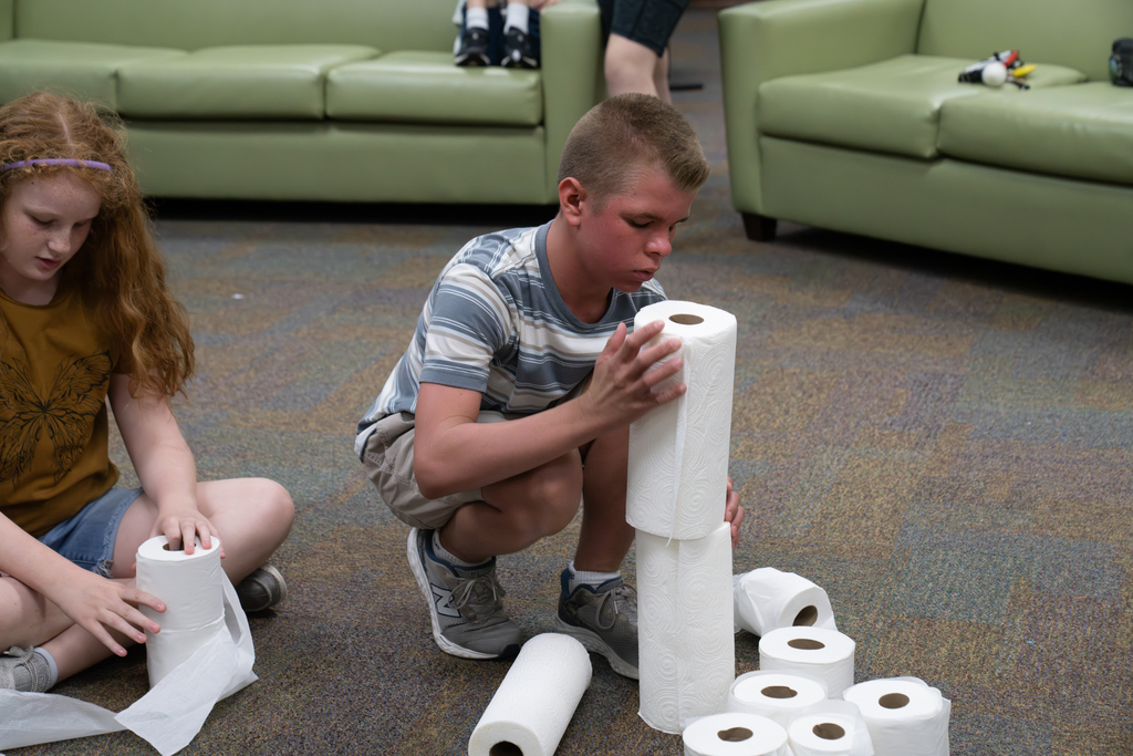 A student is building a tower with paper towels